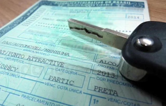 Documentos de veículo e chave sobre a mesa